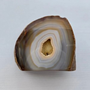 Close-up of a Natural Banded Agate Geode showcasing its layered, banded patterns and subtle earthy hues