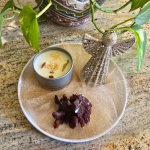 A decorative set featuring a glittery angel figurine, an Abundance Soy Candle in a tin, and a dark crystal quartz cluster, all arranged with gold mesh tulle.