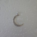 A brass crescent moon pendant with intricate filigree designs, measuring 2 inches in size.