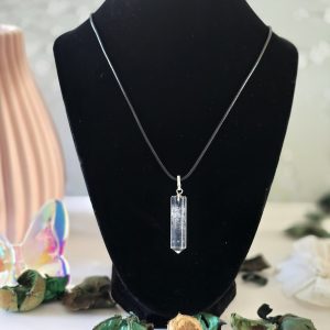 A clear crystal quartz pendant hanging from a Korean wax black cord, displayed on a white background.