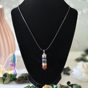 A cap pencil pendant representing the seven chakras, hanging from a sturdy Korean wax black cord.
