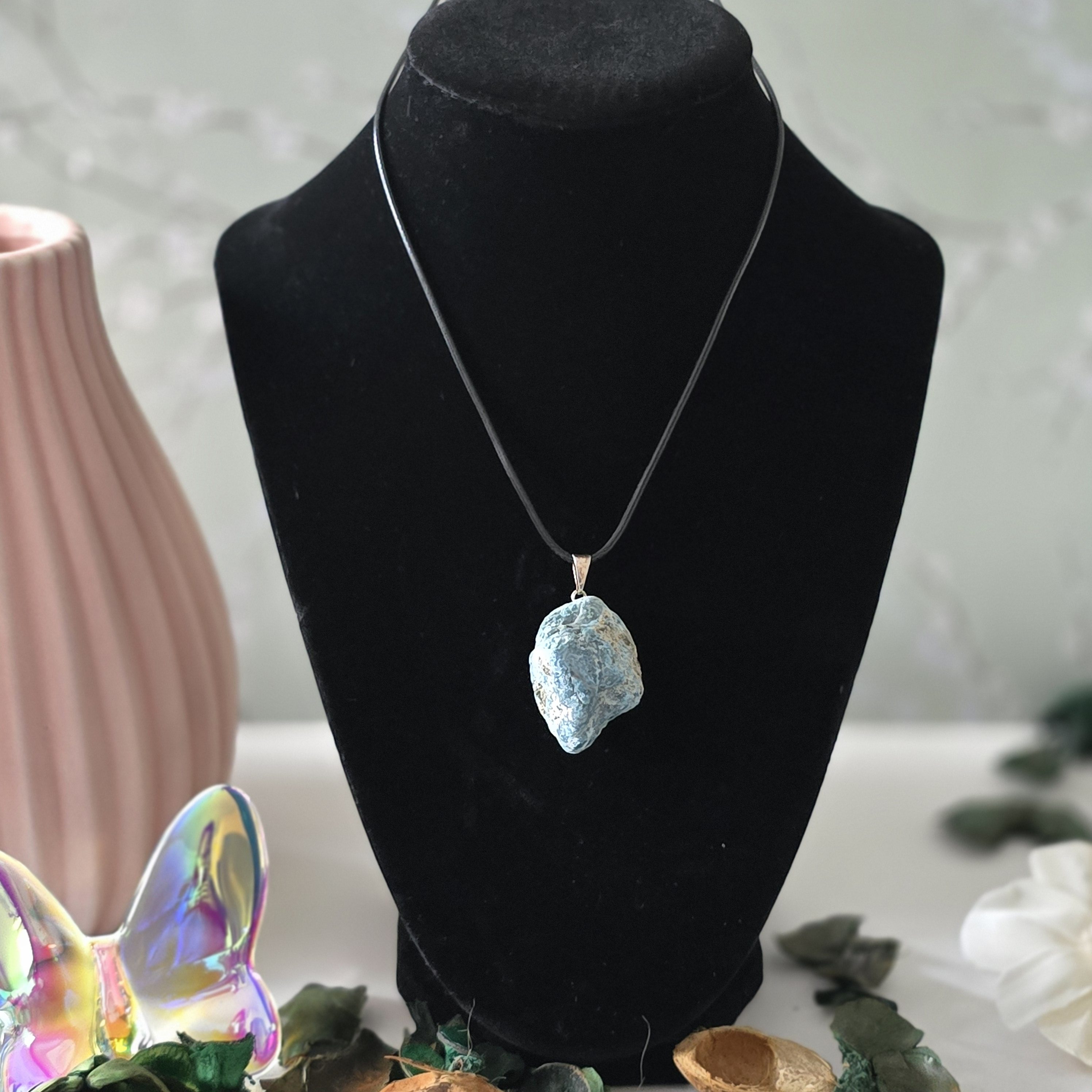 A rough blue apatite pendant hanging from a sturdy Korean wax black cord