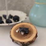 A rough tourmaline pendant displayed on a black velvet display.