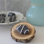 A rough purple garnet pendant displayed on a piece of wood.
