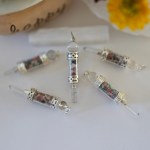Five stunning chakra stone pendulum pendants displayed on a piece of natural selenite stick.
