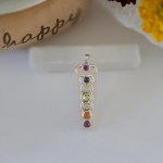 A stunning rose quartz chakra pendant displayed on a piece of natural selenite stick.