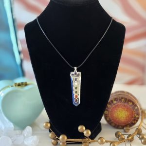 A stunning sodalite chakra necklace displayed on a black velvet display, featuring a 220-inch Korean Black cord.