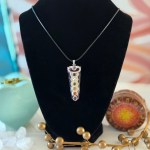 A stunning amethyst chakra necklace displayed on a black velvet display, featuring a 22-inch Korean Wax Black cord.