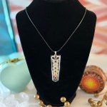 A stunning clear quartz chakra necklace on a black velvet display, featuring a 22-inch Korean Wax Black cord