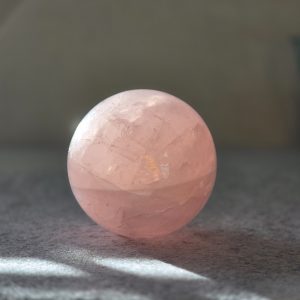Close-up view of Whispers of Love Rose Quartz Sphere showcasing its beautiful pink hues.