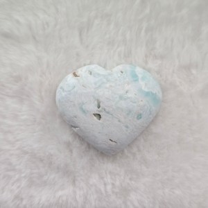Ethically sourced Caribbean Blue Calcite heart-shaped stone with vibrant blue hues and smooth contours on a natural background