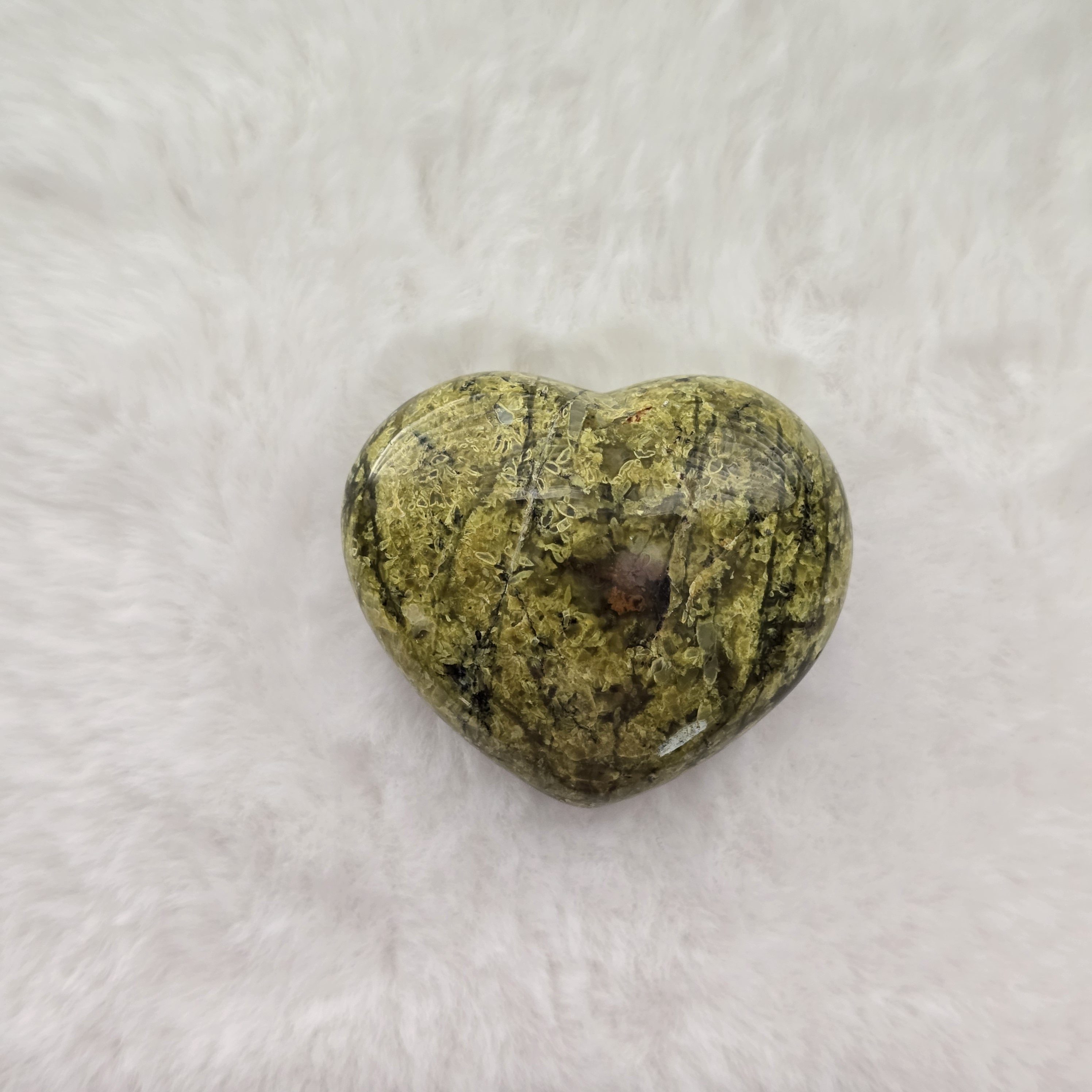 Ethically sourced serpentine heart-shaped stone with smooth, natural curves on a clean background