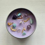Intuition Crystal Candle - Top view showcasing Amazonite and Amethyst crystals with botanical elements.