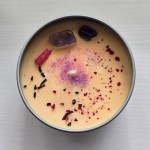 Eternal Beauty Crystal Candle - Top view showcasing Raw Pink Rhodonite and Purple Fluorite crystals with botanical elements.