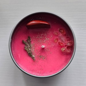 "Strength Crystal Candle - Top view showcasing Red Jasper and Citrine crystals with botanical elements