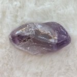 Close-up of a single Amethyst tumbled stone, showcasing its rich purple tones and smooth, polished surface.