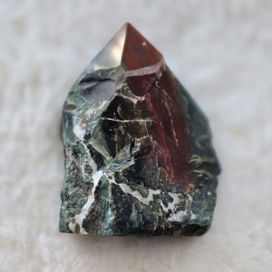 Ethically sourced Indian Turquoise point featuring vibrant red, blue, and green hues with striking white lines and a sharp, carved tip